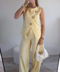 Geel damespak met gouden knopen